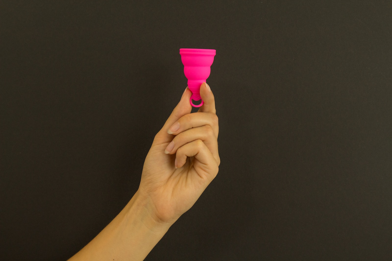 a person holding a pink cup in their hand